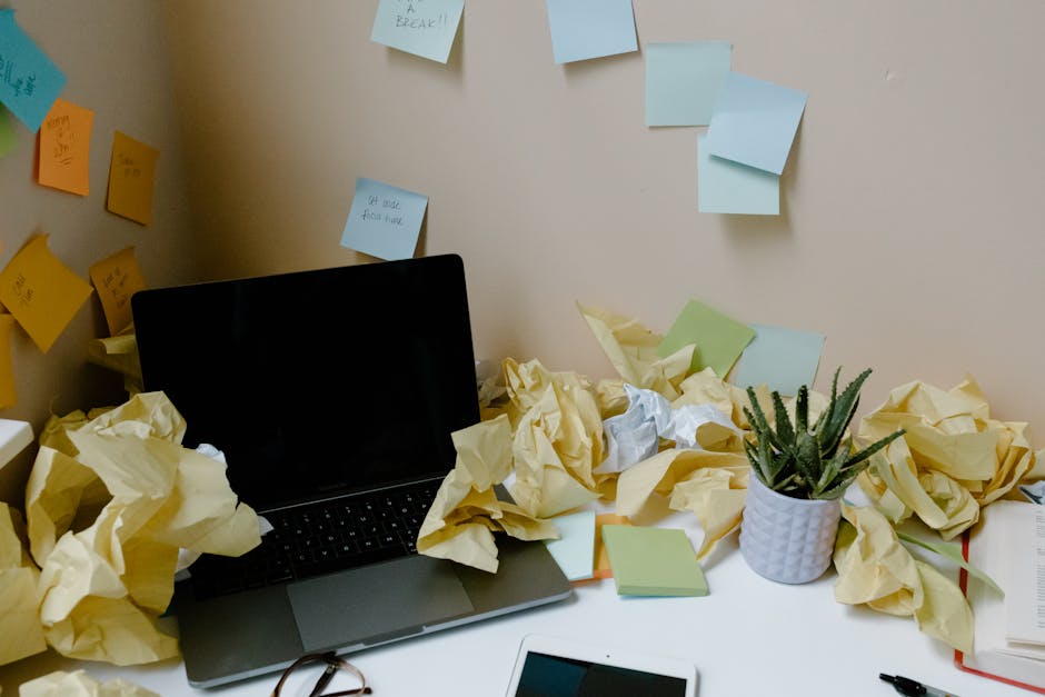 creator at a desk building a challenge outline on a laptop, sticky notes with daily topics on the wall