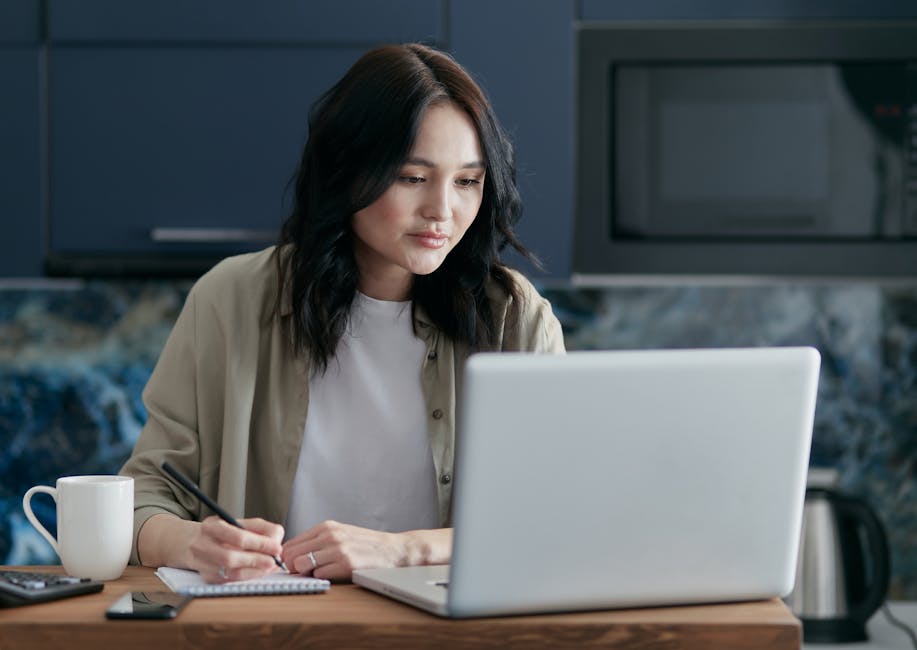 professional woman working at home office laptop with notes and coffee