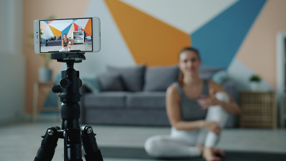 Fitness Influencer Paid Challenge 2026: How to Turn Your Following Into Recurring Revenue 1 fitness influencer paid challenge - Female fitness vlogger using smartphone to record a session in stylish living room.