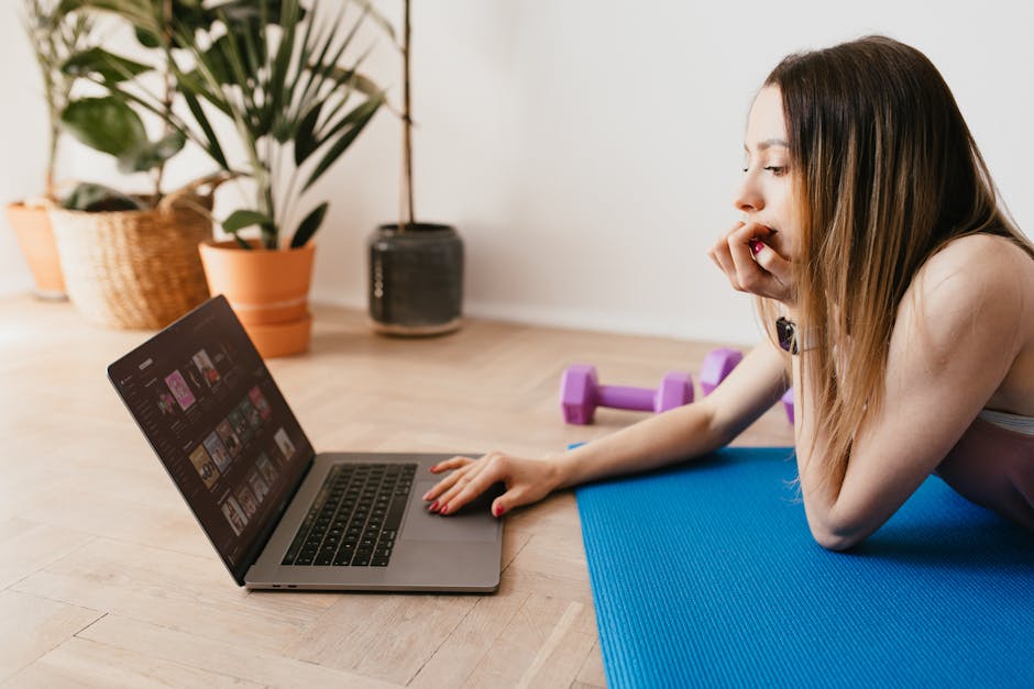 Fitness Influencer Paid Challenge 2026: How to Turn Your Following Into Recurring Revenue 3 fitness influencer paid challenge - Side view of young slim female using laptop while lying on blue rubber mat during workout