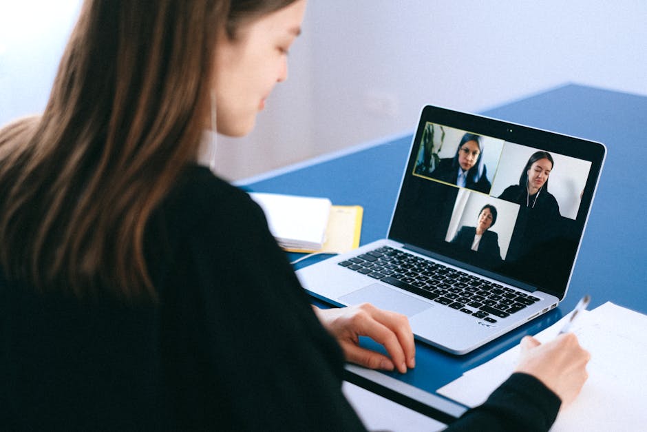 Laptop showing Zoom meeting with multiple video participants